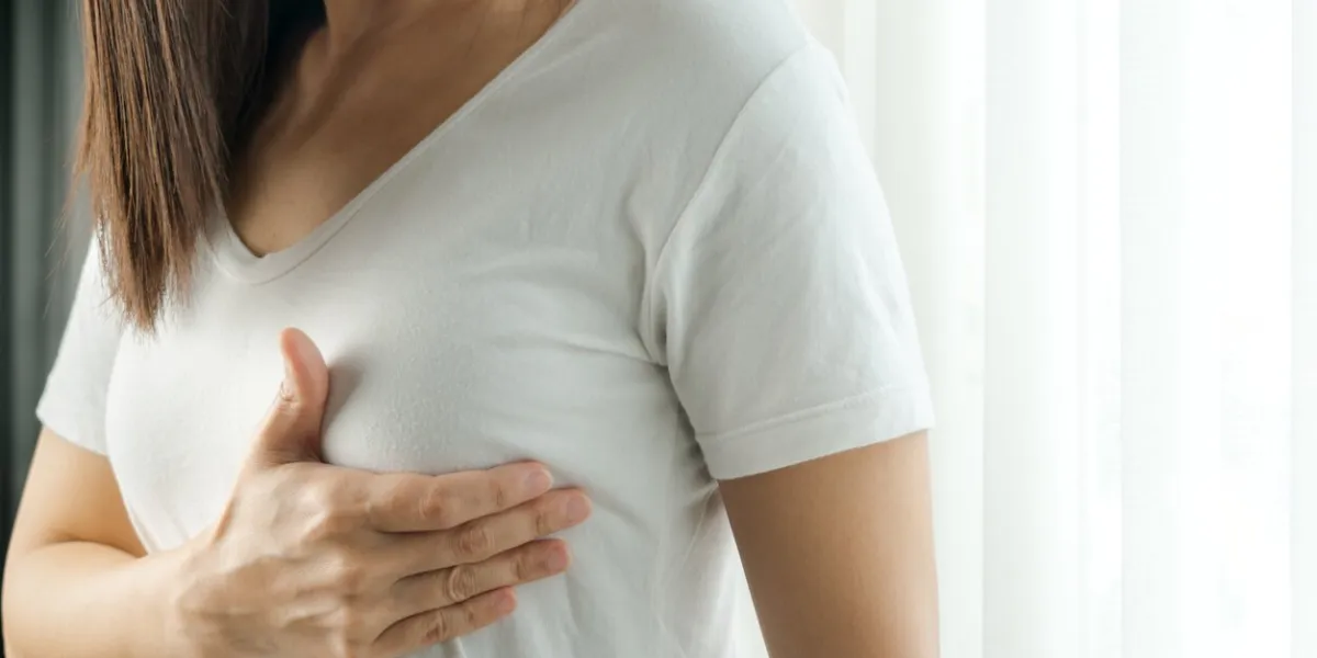 woman hand checking lumps on her breast for signs of breast cancer women healthcare concept