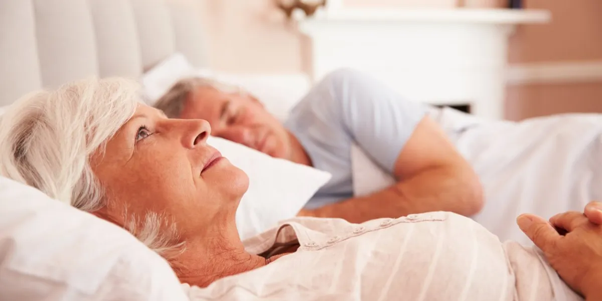worried senior woman lying awake in bed