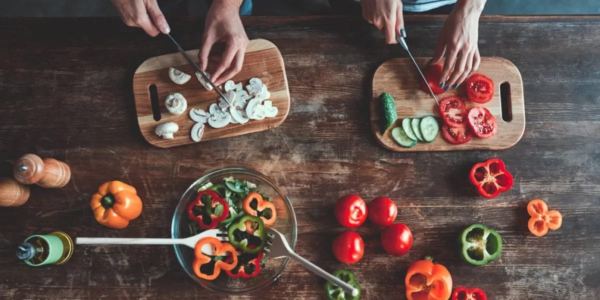 cropped image of romantic couple is cooking on kitchen handsome man and attractive young woman are having fun together while making salad healthy lifestyle concept