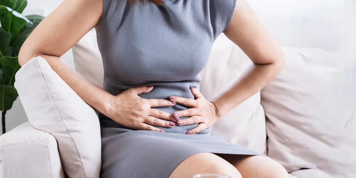 asian woman suffering from stomach pain due to gastritis and irritable bowel syndrome or digestive system problem