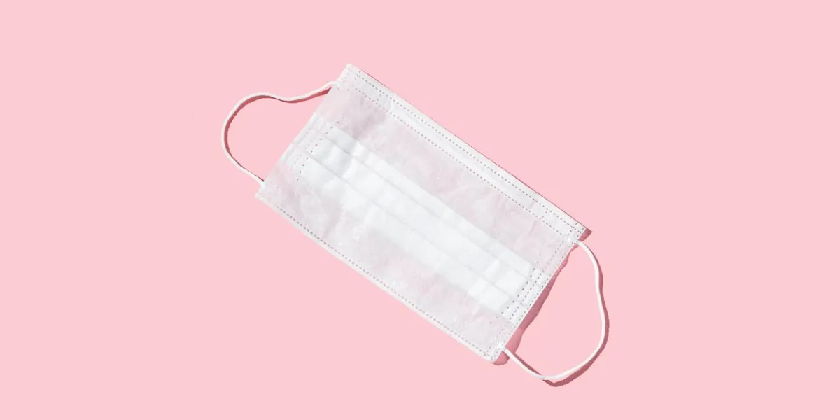 medical mask on the pink colored table epidmic concept mask to cover the mouth and nose for protection from virus and bacteria flat lay