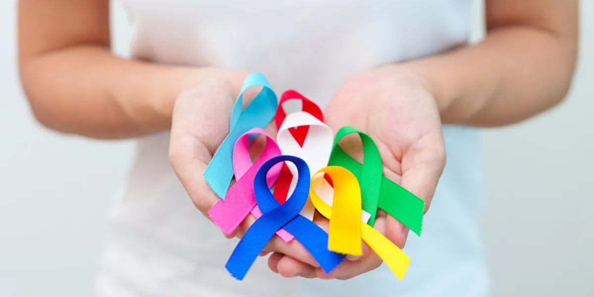 world cancer day, february 4 hand holding blue, red, green, white, pink, navy blue and yellow ribbons for supporting people living and illness healthcare and autism awareness day concept