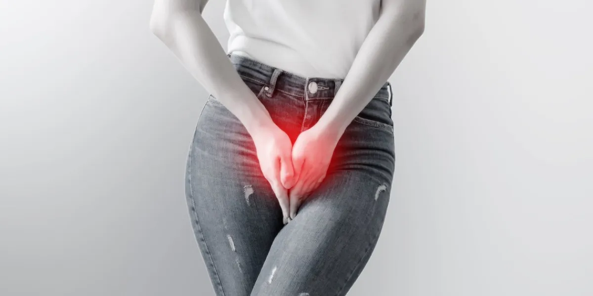 young woman in jeans standing with her hands between legs