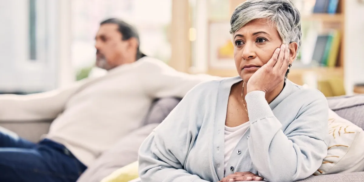 senior couple, divorce and fight in conflict, argument or disagreement on living room sofa at home elderly man and woman in stress, depression or toxic relationship for cheating affair or breakup