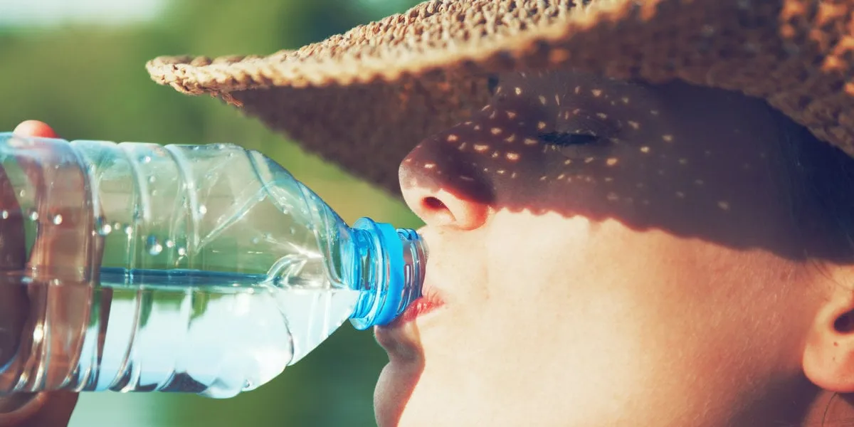 woman drinking water in summer sunlight