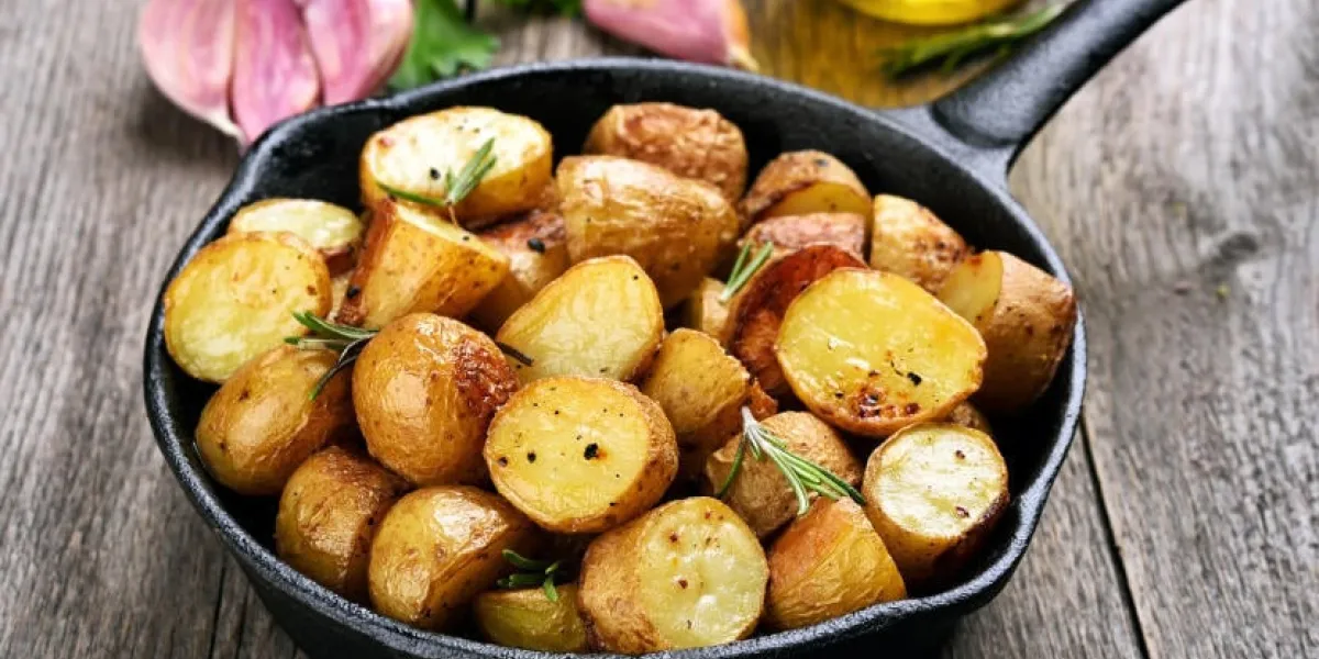 pommes de terre rôties dans une poêle sur fond en bois