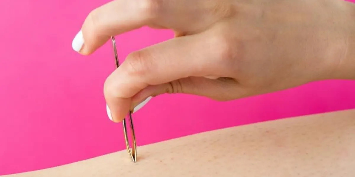 femme tirant les cheveux avec une pince à épiler