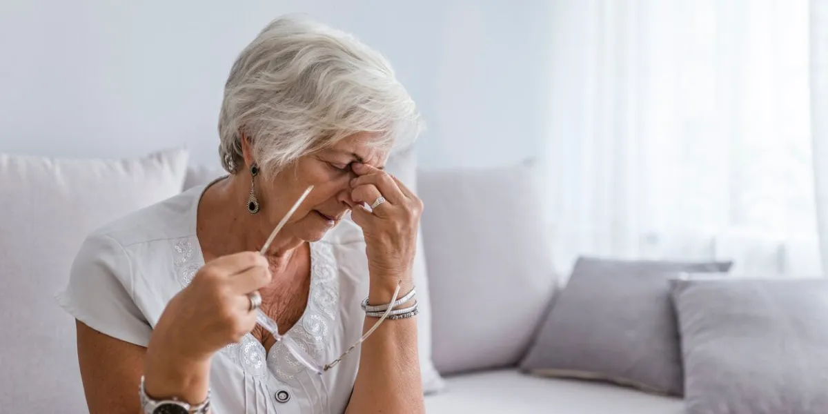 elderly woman suffering from headache at home close up aged woman with headache health care, pain, stress, age and people concept