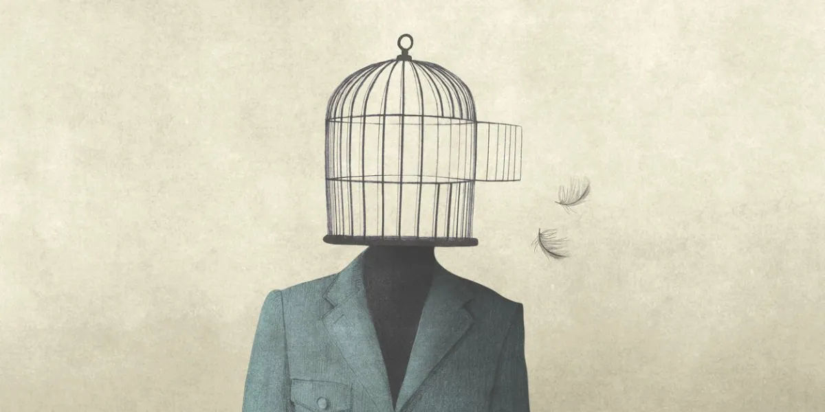 man with open birdcage over his head, surreal freedom concept