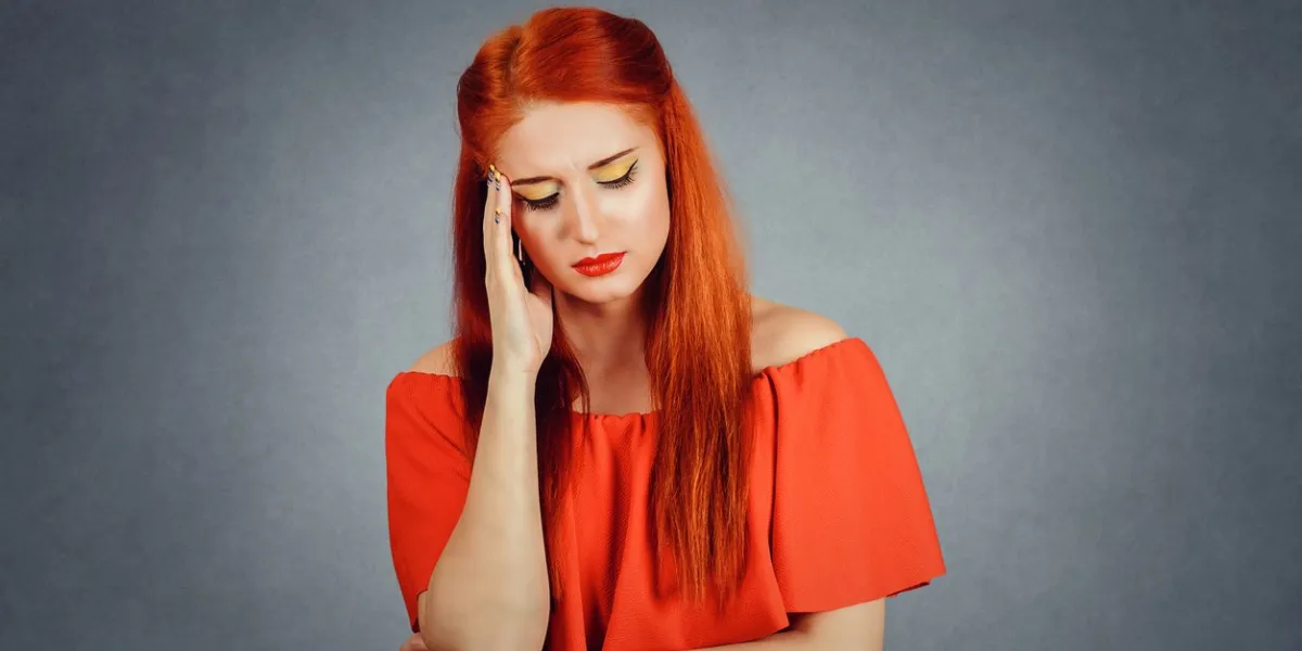 tinnitus young woman having ear pain touching her painful head temple isolated on red background with blank copy space