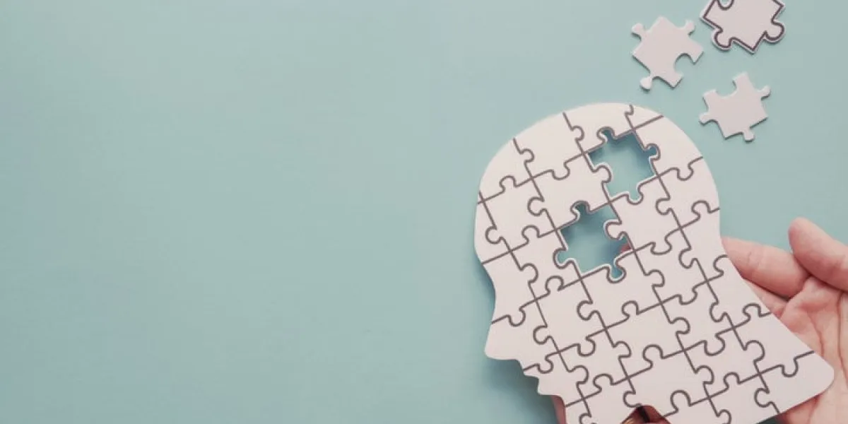 hands holding brain with puzzle paper cutout, autism, epilepsy and alzheimer awareness, seizure disorder, world mental health day concept