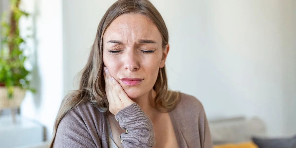 tooth pain and dentistry young woman suffering from terrible strong teeth pain, touching cheek with hand female feeling painful toothache dental care and health concept
