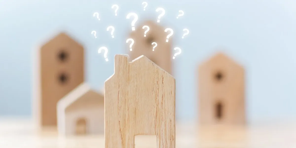 real estate developer and managing property investment concept selective focus wooden houses with question mark on table