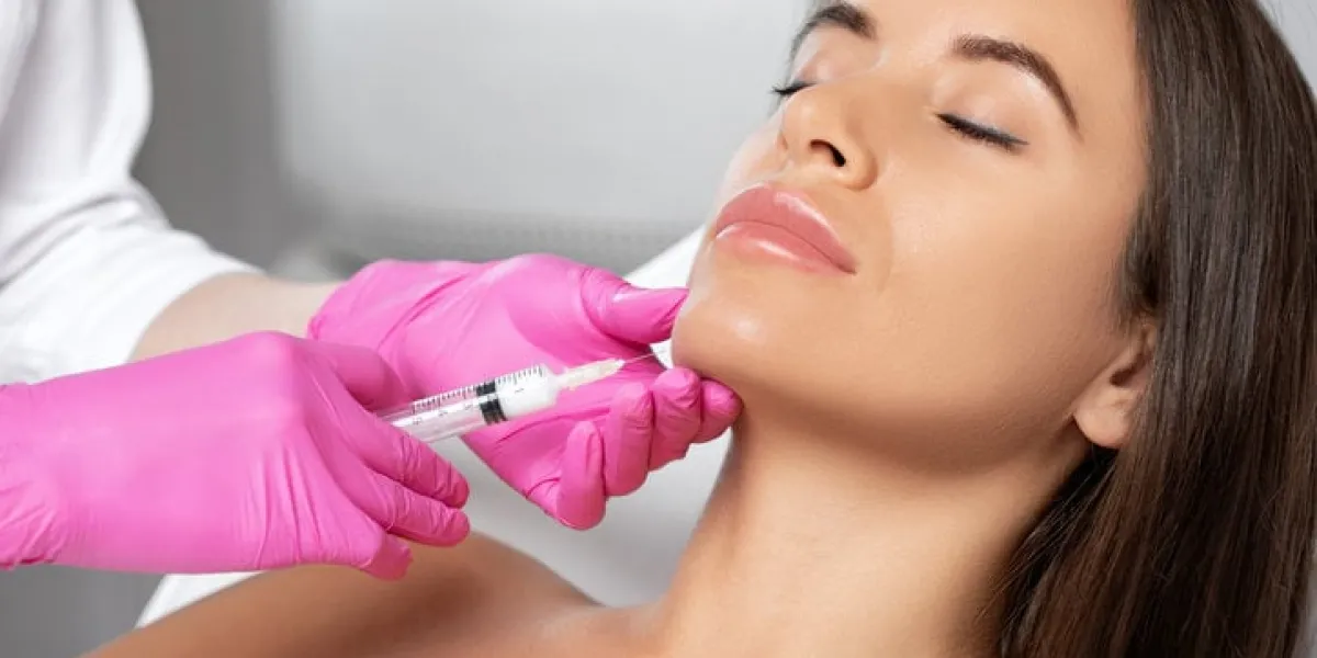 cosmetologist makes lipolytic injections to burn fat on the chin, cheeks and neck of a woman against double chin female aesthetic cosmetology in a beauty saloncosmetology concept