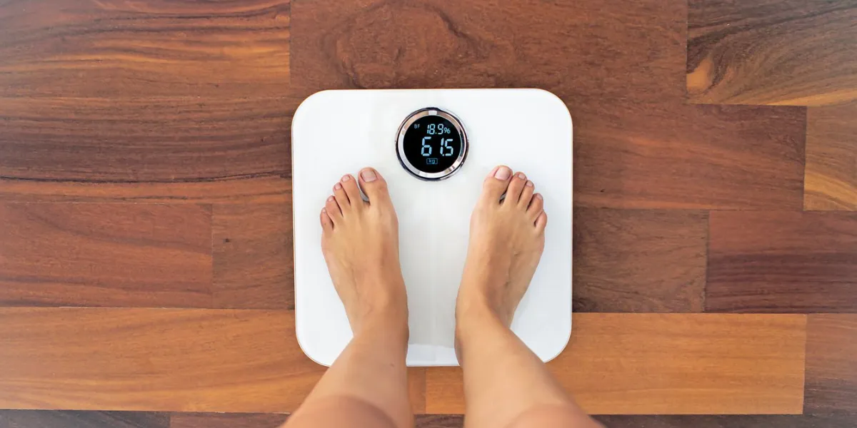top view of woman bare feet standing on a digital scale with body fat analyzer that uses bioelectrical impedance (bia) to gauge the amount of fat in your body