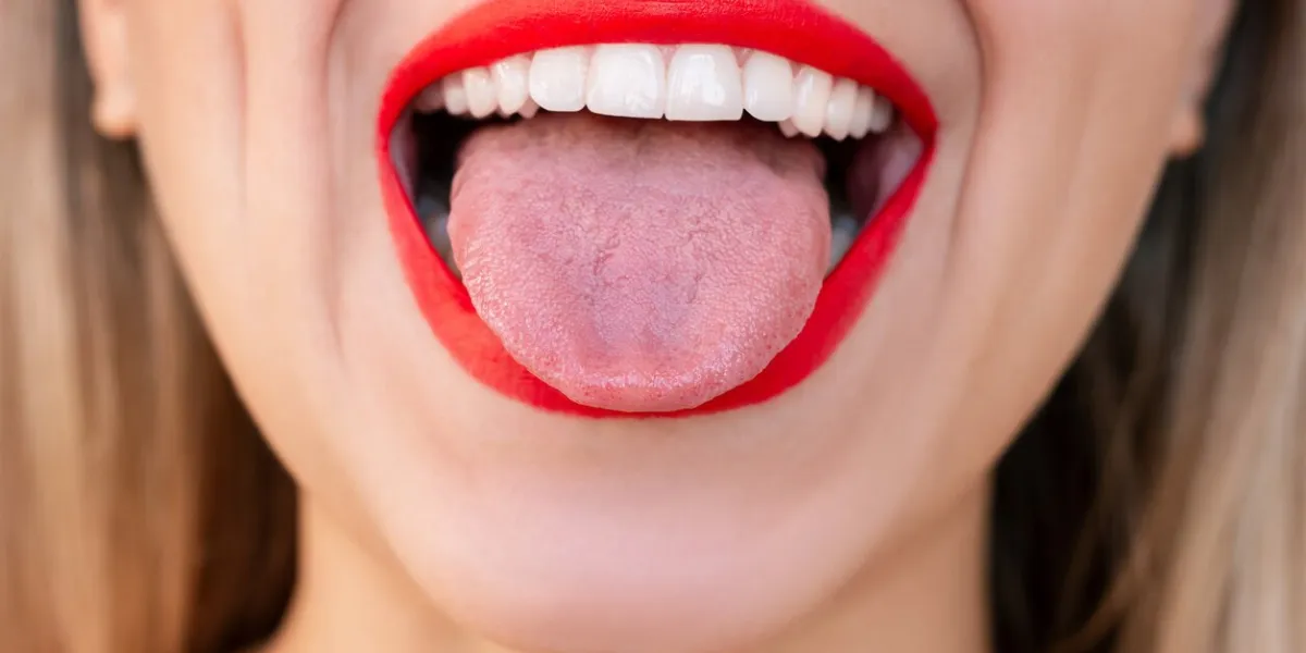cropped shot of cheerful young caucasian blonde woman sticking out tongue with her mouth wide open female lips with red lipstick teeth whitening oral hygiene, dental health caregirl showing tongue
