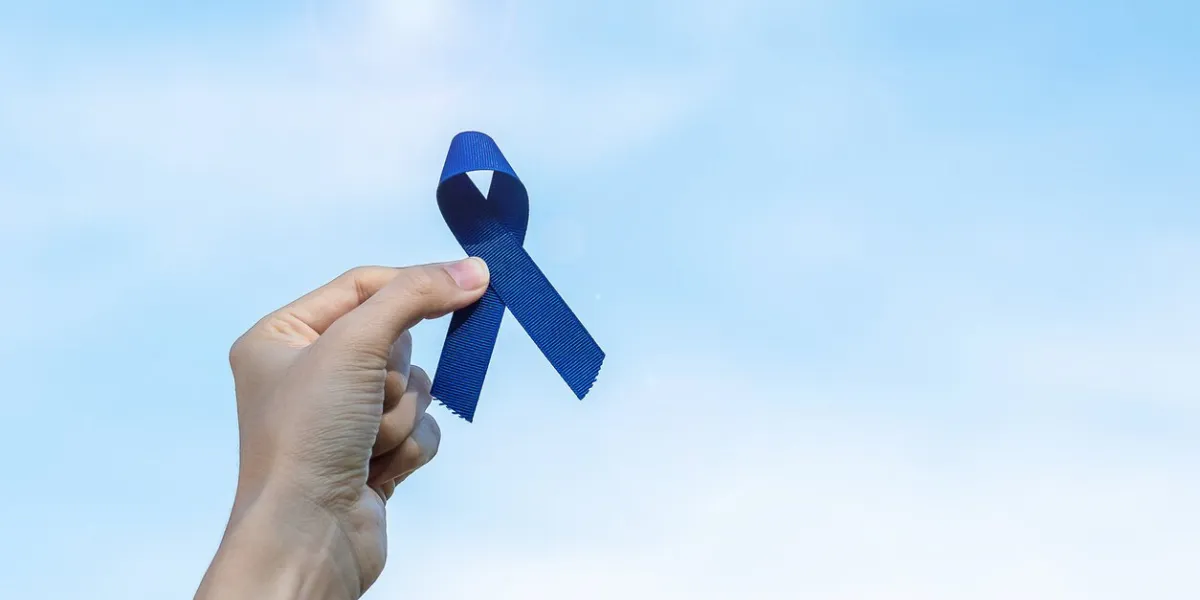 march colorectal cancer awareness month, woman holding dark blue ribbon for supporting people living and illness healthcare, hope and world cancer day concept
