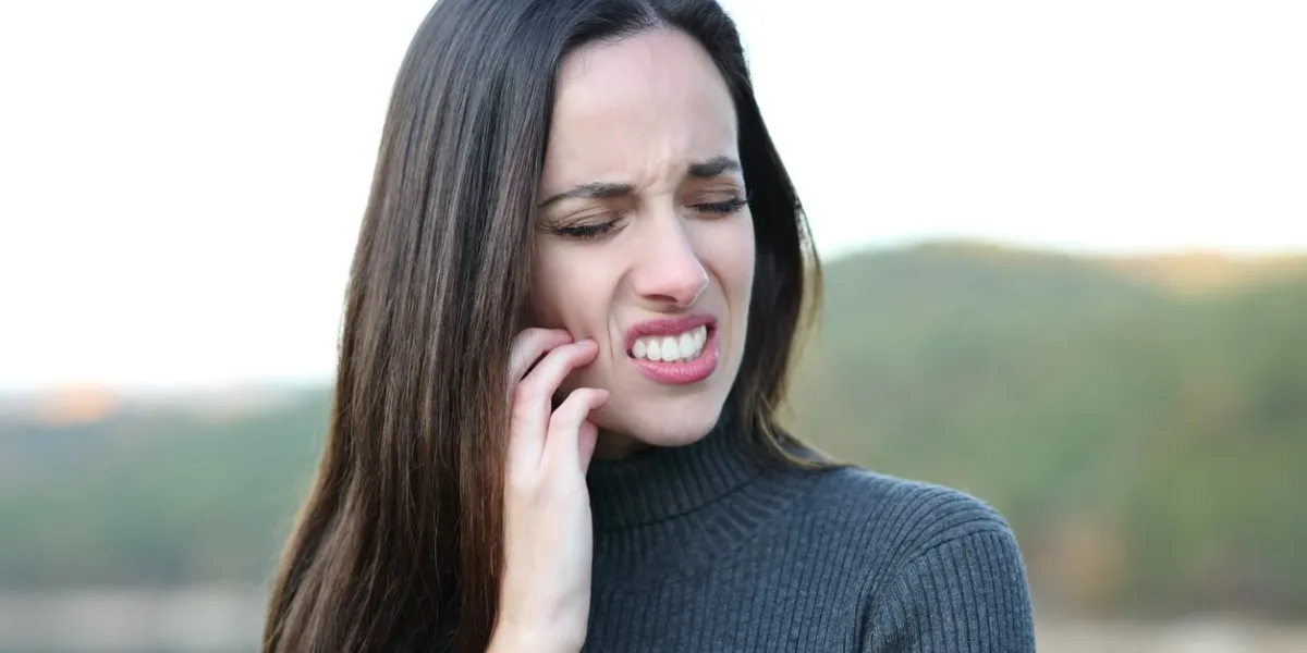 stressed woman scratching itchy face in winter