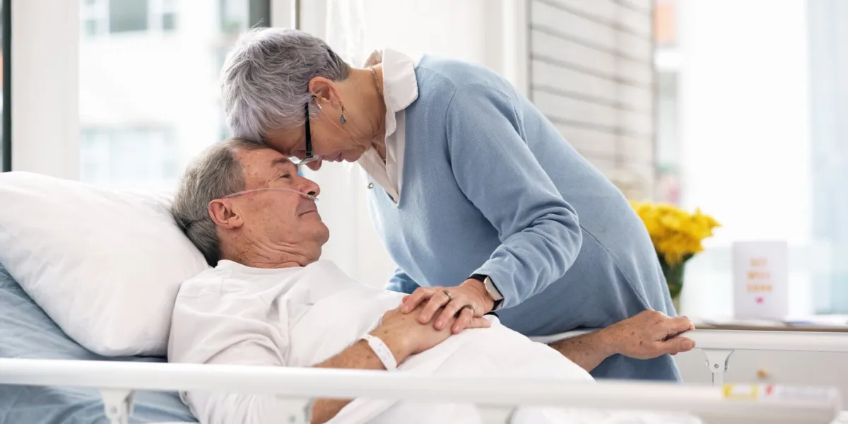 hospital, love or elderly couple, sick patient and affection for empathy, marriage bond and support for senior person retirement healthcare, forehead and man with medical problem, cancer or disease