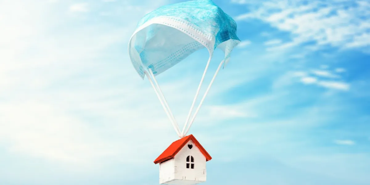 a toy house flies on a parachute from a medical mask the concept of a protected house from viruses