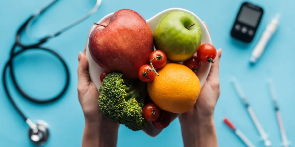 fruits and vegetables in female hands with medical equipment on blue background