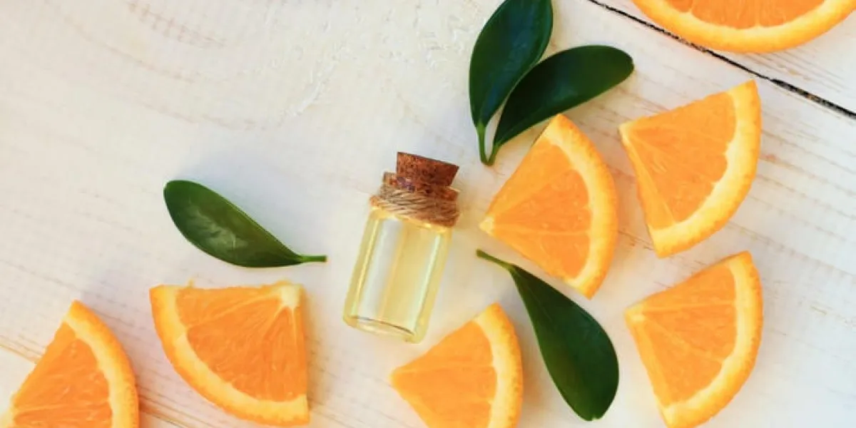 bouteille avec de l'huile essentielle, agrumes dispersés sur une table en bois