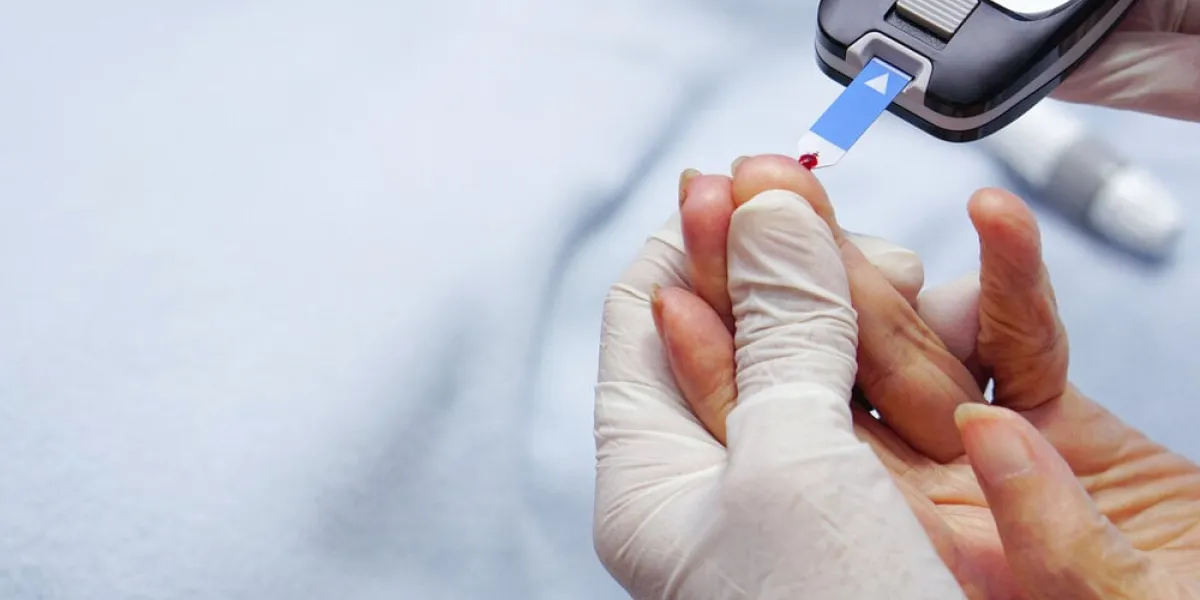 doctor wear gloves using lancet on finger for checking blood sugar level by glucose meter
