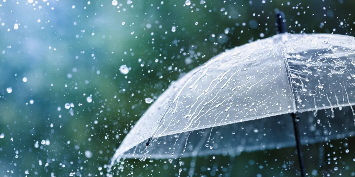 transparent umbrella under heavy rain against water drops splash background rainy weather concept