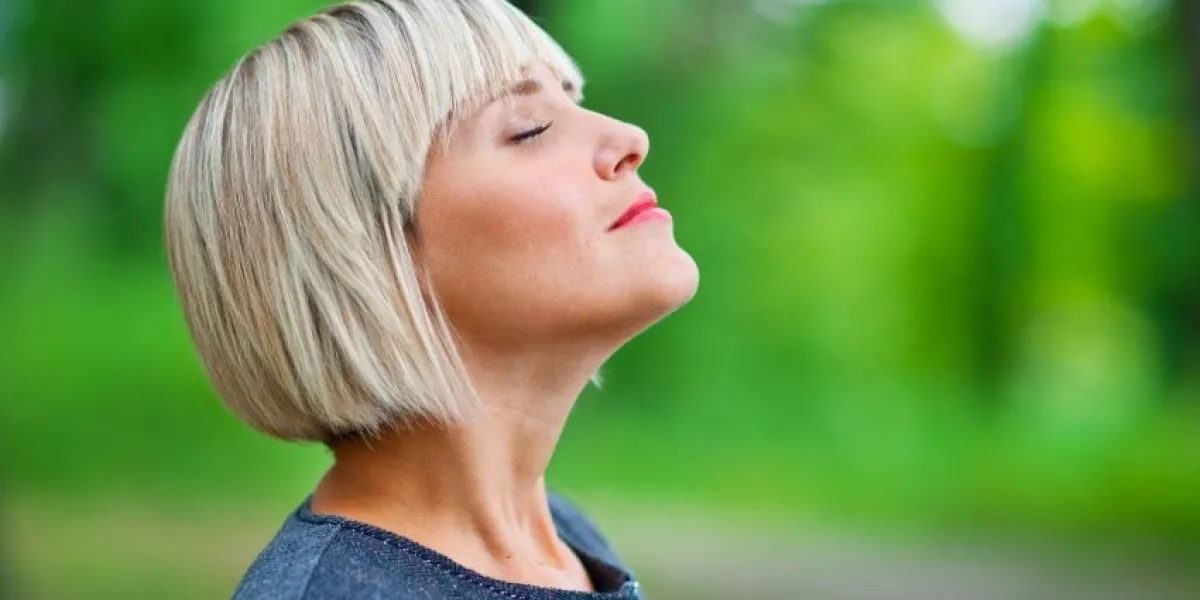 attractive blond woman breathing and relaxing in nature