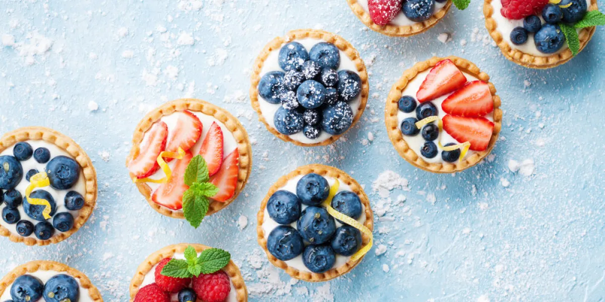 healthy summer pastry dessert berry tartlets or cake with cream cheese top view