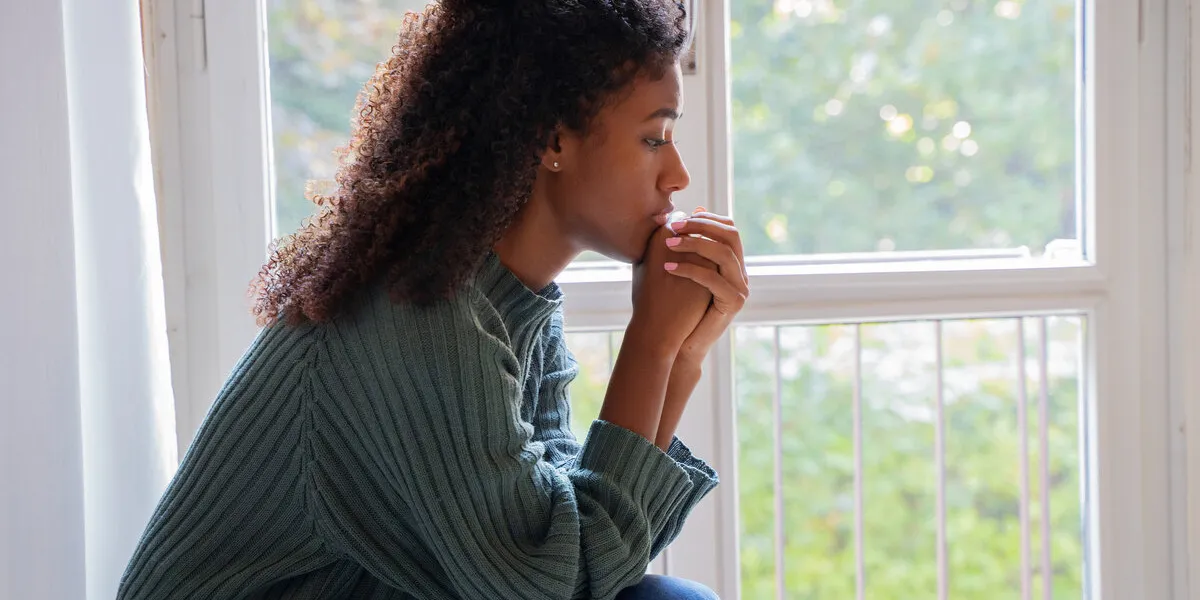 black woman feeling depression symptoms alone at home