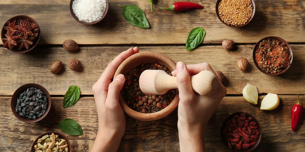 female hands grinding spices in mortar