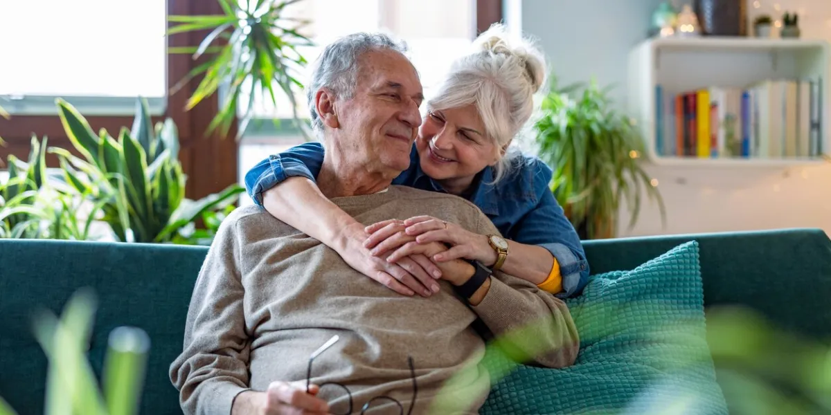 portrait of a happy senior couple sitting on sofa at home
