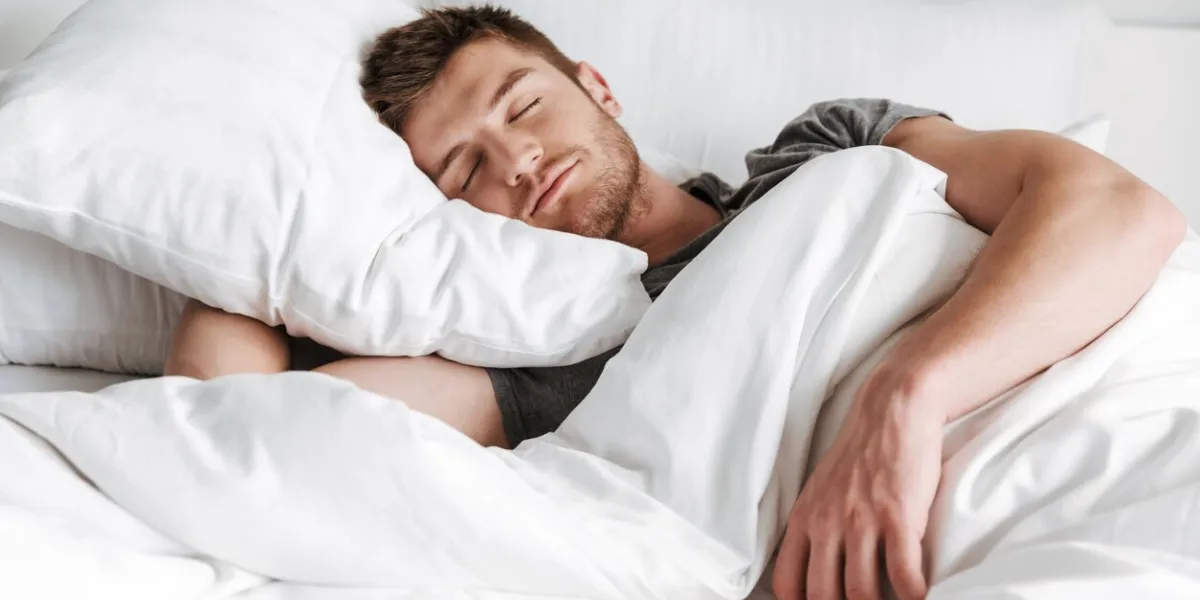 handsome young man sleeping in bed at home