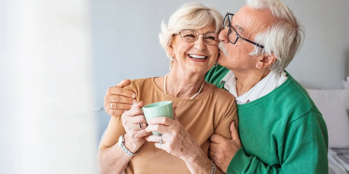portrait of smiling senior couple cropped portrait of a senior man affectionately embracing his wife at home senior man and woman standing in new house looking at camera