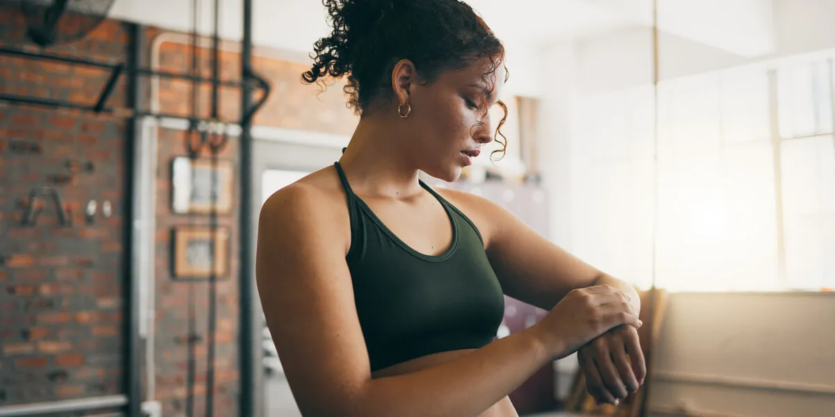 fitness, smartwatch and gym workout progess of a woman doing exercise, training and body wellness young sports female or athlete with app for time while active to be strong, healthy and for energy