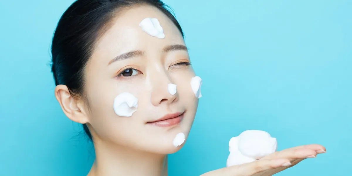 young asian woman and cosmetic textures photographed on blue background