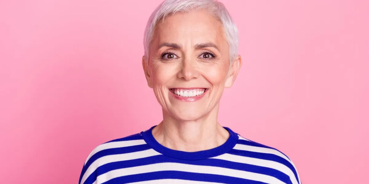 photo of lovely cheerful senior woman wear striped stylish clothes isolated on pink color background