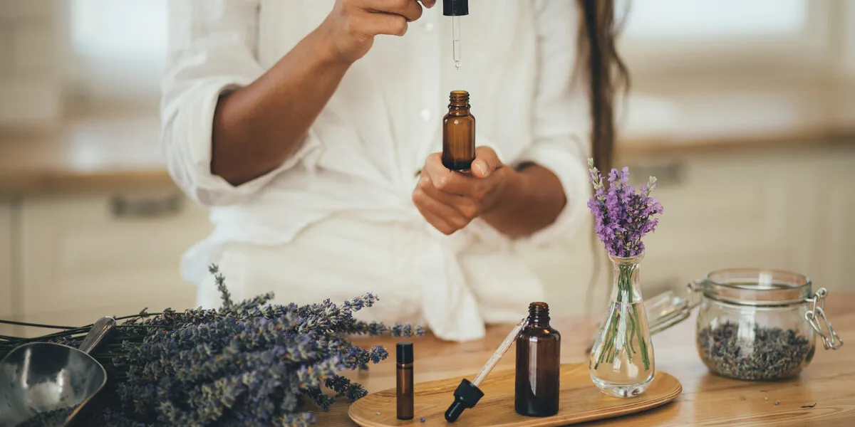 young woman applying natural organic essential oil on hair and skin home spa and beauty rituals skin care