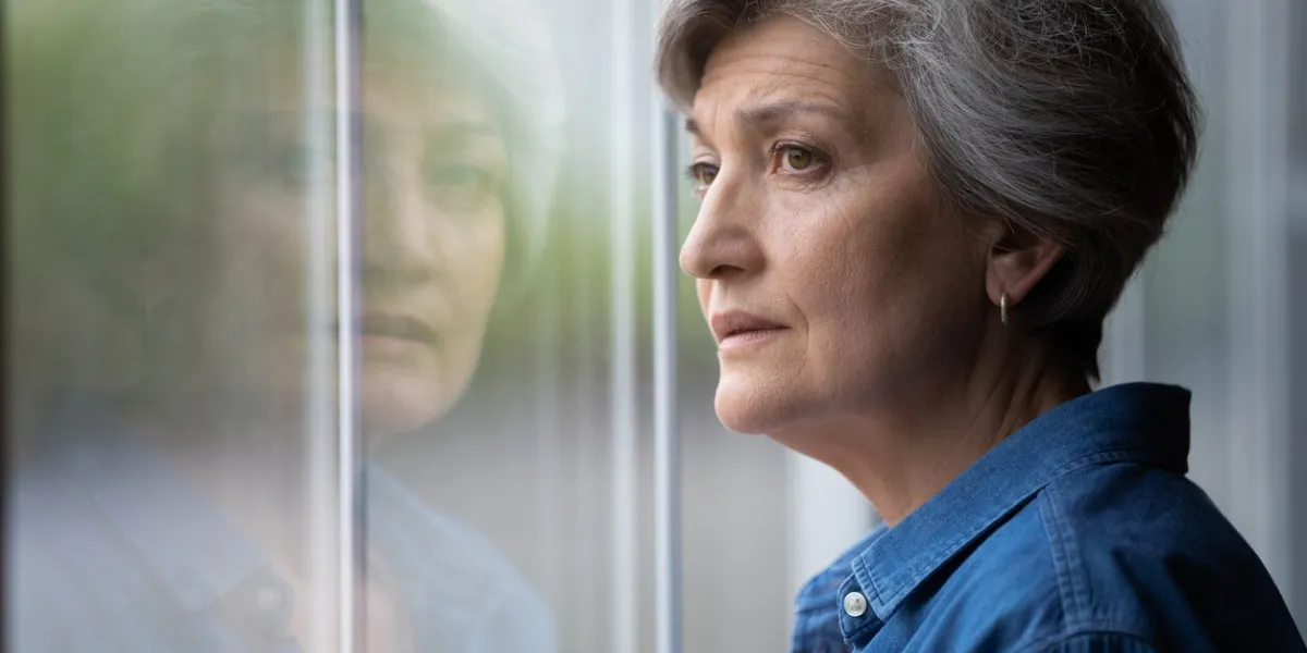 close up thoughtful upset mature woman looking out window at home alone, sad senior grey haired female lost in thoughts, thinking about problem, nostalgia and melancholy, feeling lonely