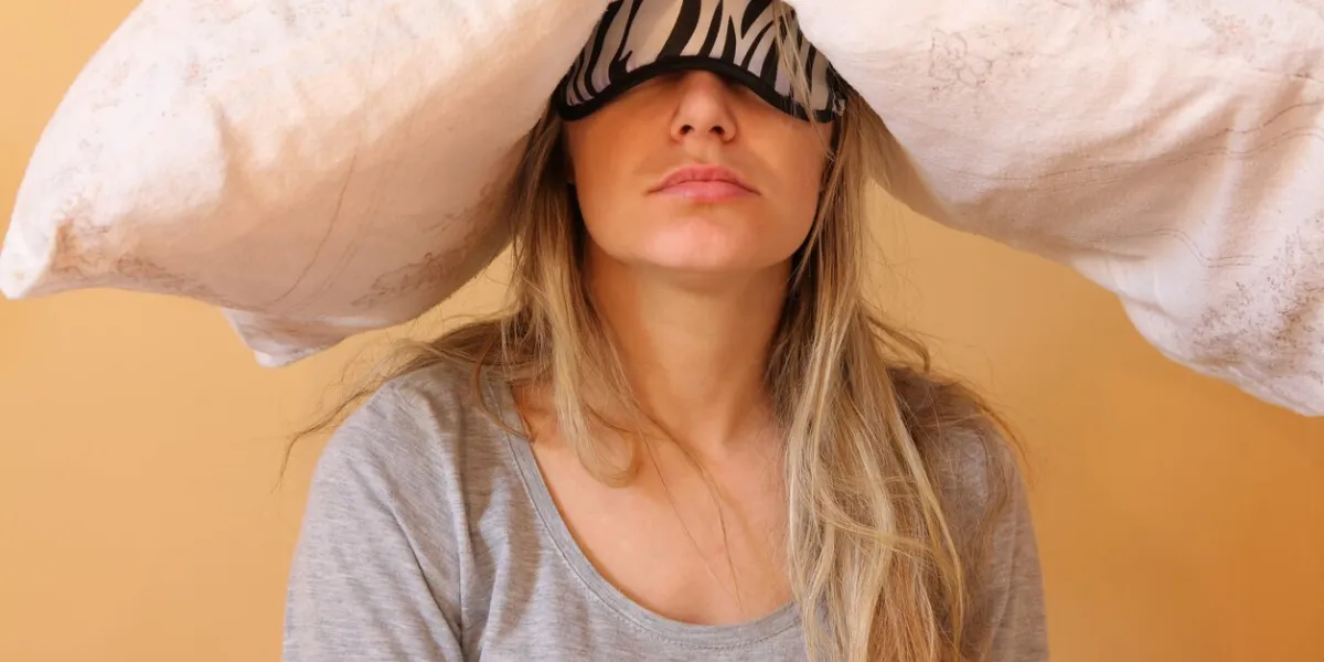 sleepy young women with pillow and sleeping eye mask still on