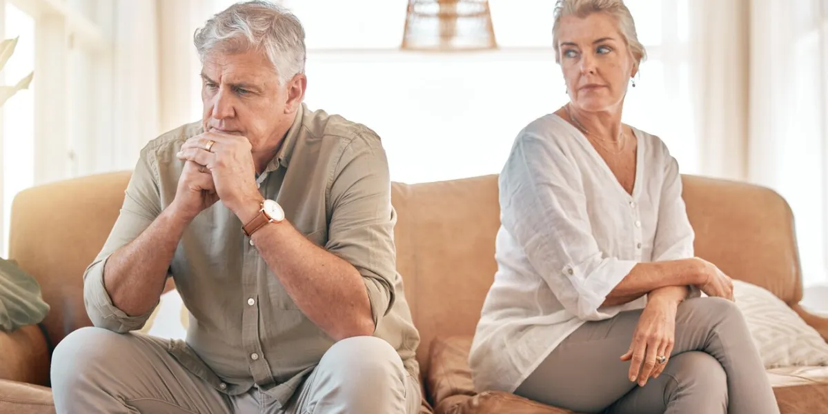 senior couple, divorce and disagreement in conflict, fight or argument on living room sofa at home elderly woman and frustrated man in depression, cheating affair or toxic relationship in the house