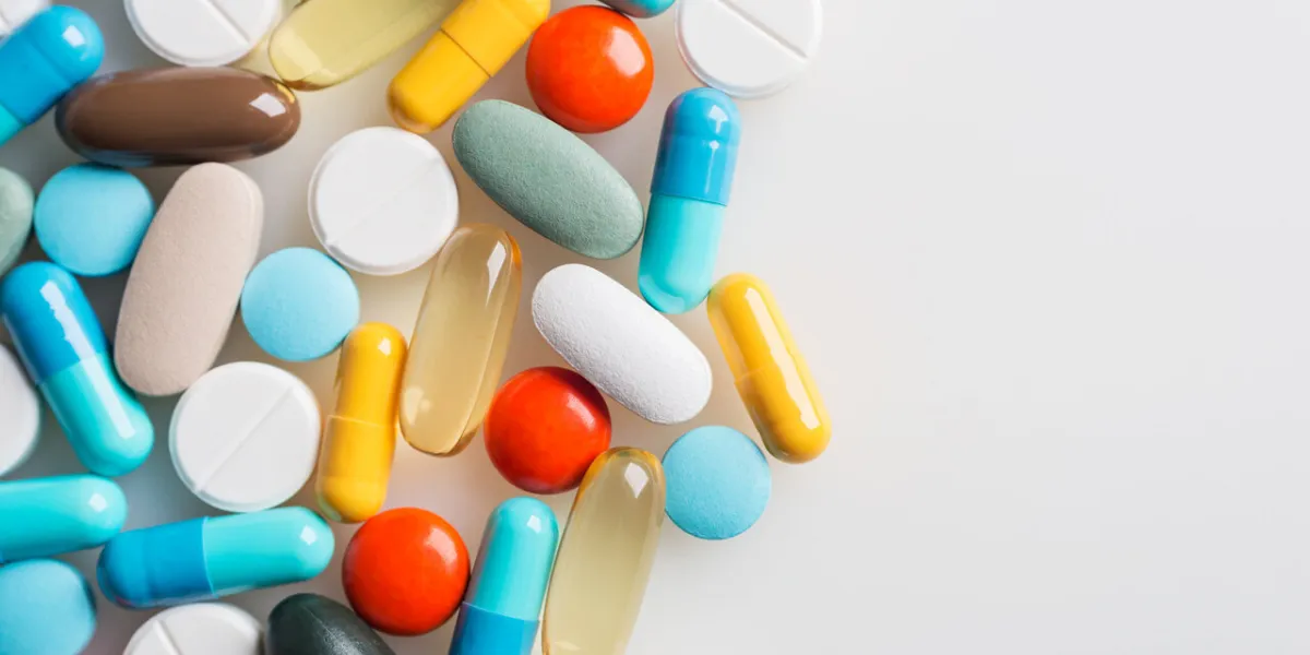 composition with colourful pills and light grey background