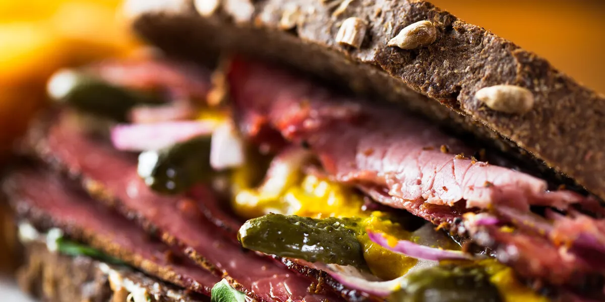 detail of pastrami sandwich with french fries ready to eat