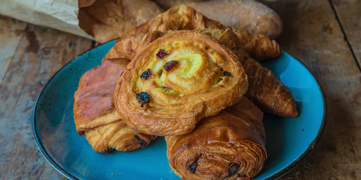 various of french viennosieries and breads on rustic wooden back