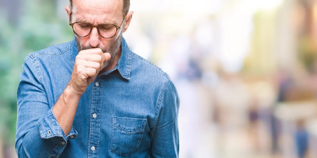 middle age hoary senior man wearing glasses over isolated background feeling unwell and coughing as symptom for cold or bronchitis healthcare concept