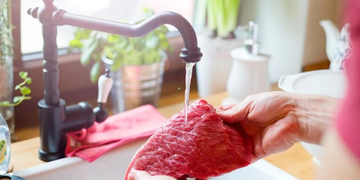 homme méconnaissable dans la cuisine prépare le bifteck