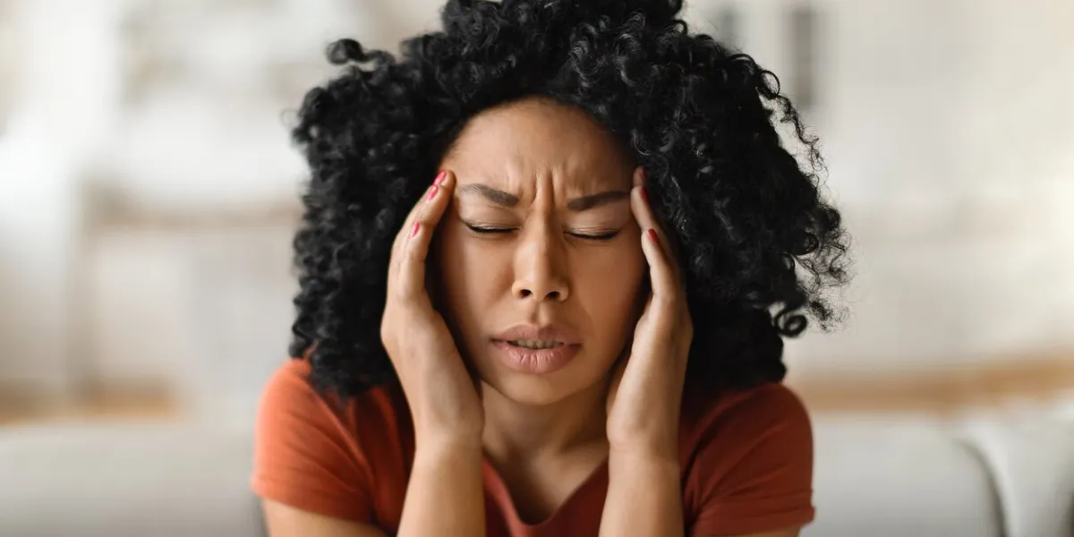 migraine concept closeup shot of stressed black woman touching head with hands, young african american female massaging temples, suffering acute headache while relaxing at home, free space