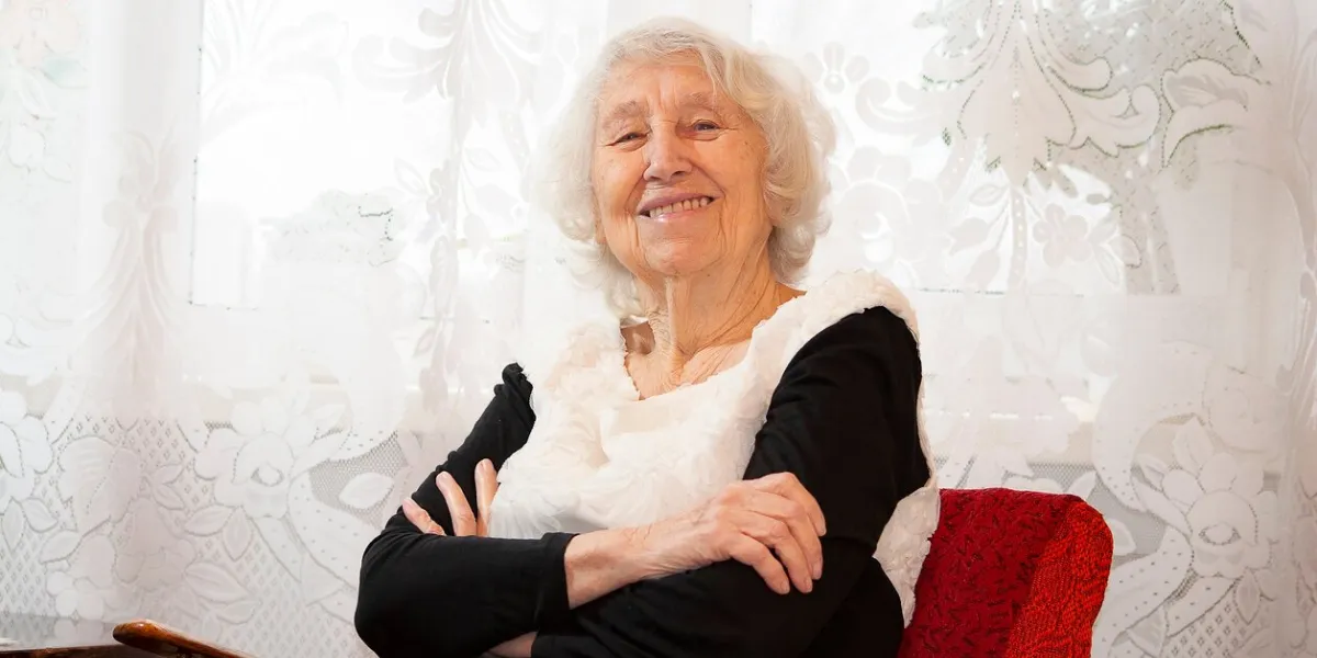the portrait of a cheerful smiling senior woman over home background