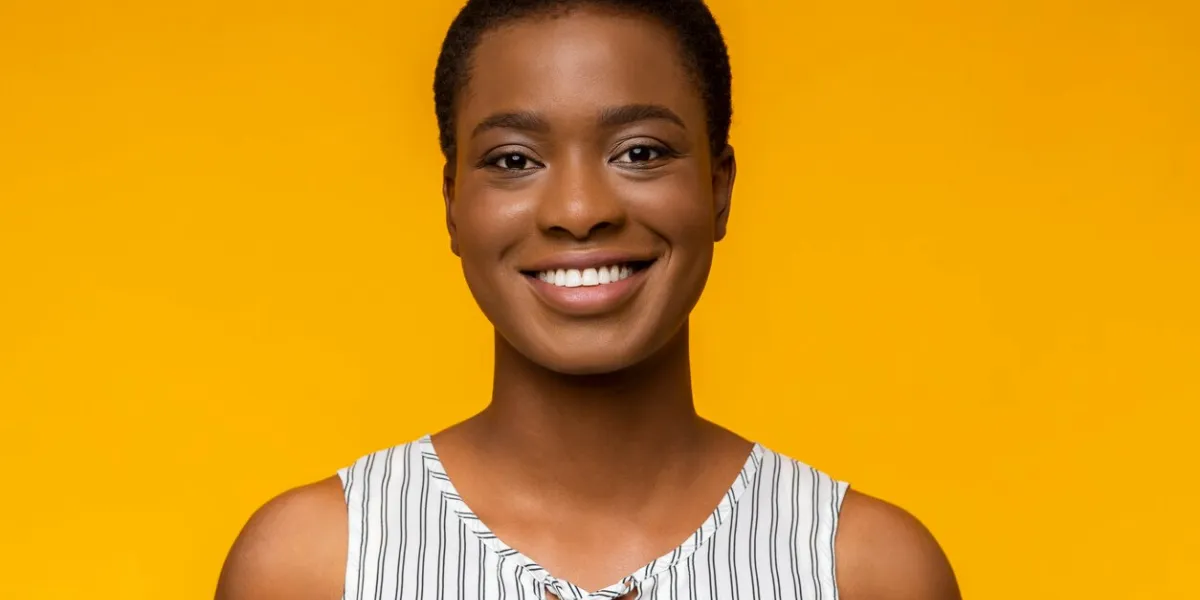 youth and beauty concept portrait of young smiling african american girl on yellow background